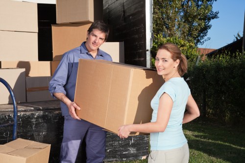 Removal team carrying furniture through a Bayswater flat entrance